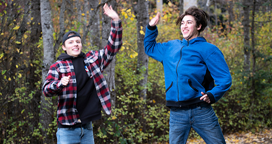 Dawson and Sol jump to high five outside the university's Bob Wright building