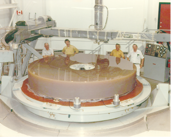 Roy Dancey (far right) stands with the Canada France Hawaii Telescope mirror and 3 colleagues