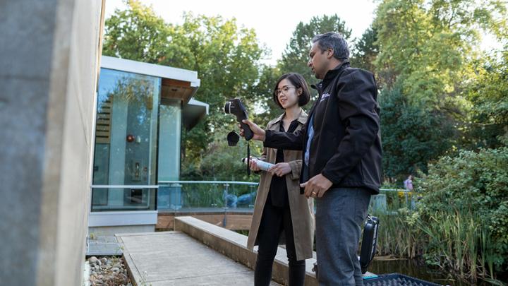 A student and supervisor taking readings outdoors for research