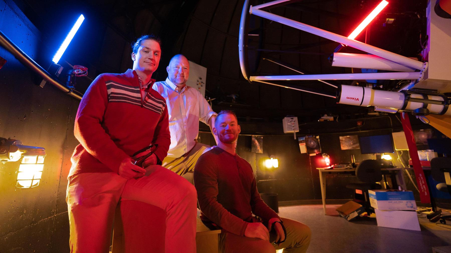 Three graduate students working in an observatory