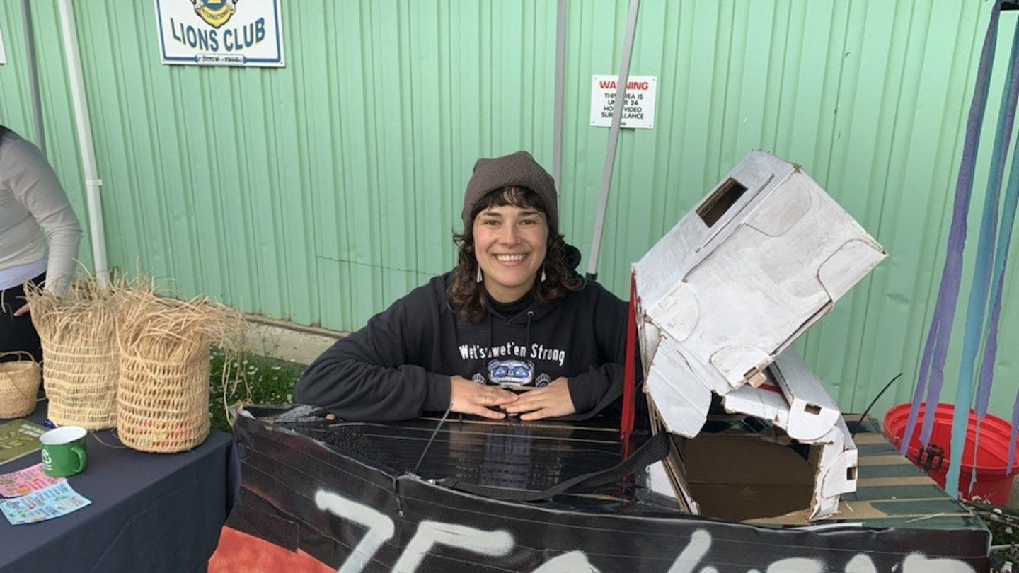 Julia Weder, UVic Sustainability Scholar, smiling at a table in a market