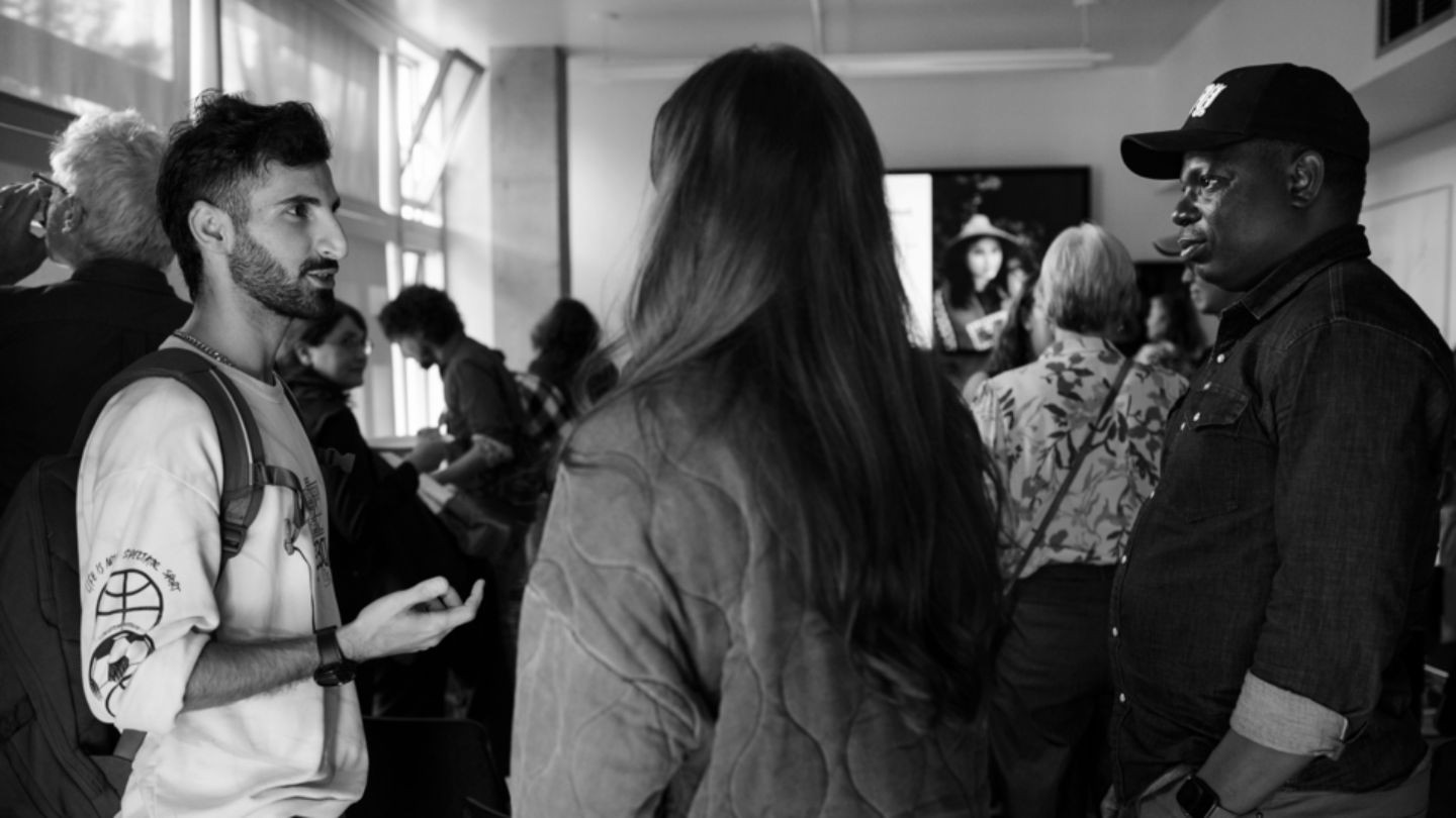 People gathered standing and chatting at a Scholars event