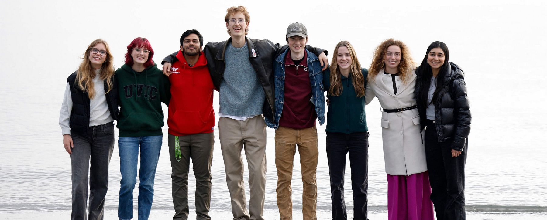 BCom students arm-in-arm at Cadboro Beach at Gyro Park