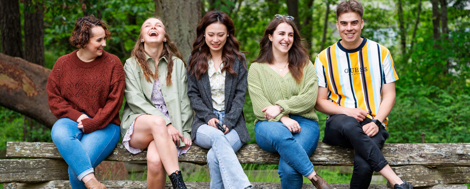 BCom students sitting on a fence at the University of Victoria