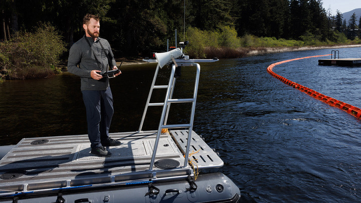 Brant Chlebowski operating a robot boat from the shore