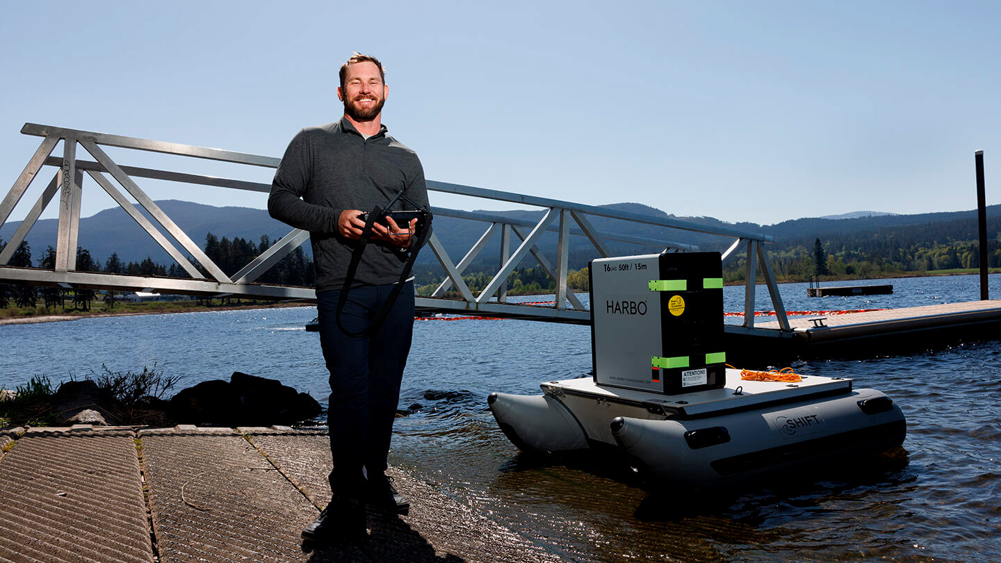 Brant Chlebowski operating a robot boat from the shore