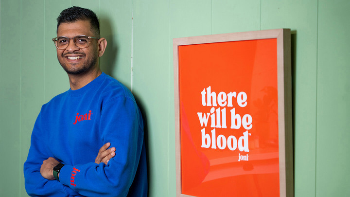 Jayesh Vekariya from joni next to a sign that says There will be blood