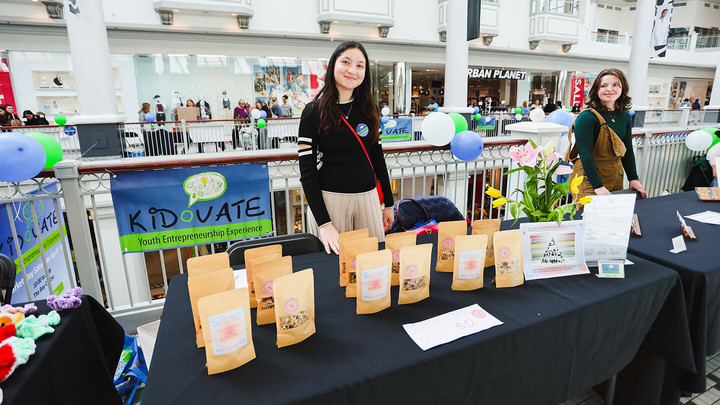 A participant at Kidovate selling tea at their table