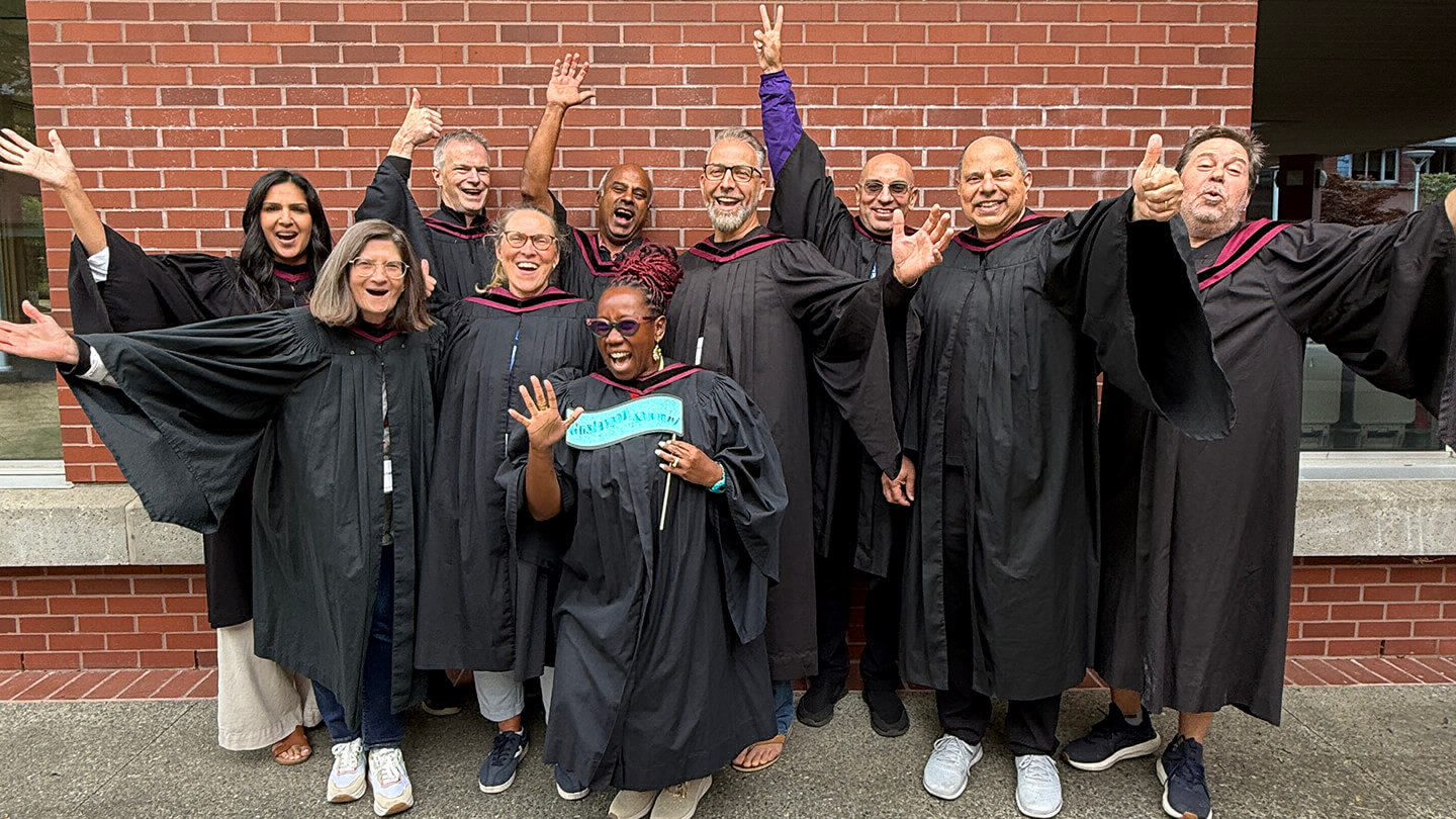 MBA class of 2001 wearing graduation gowns at their 25 year reunion