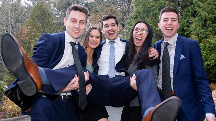 Students from the RBC Case Competition celebrate with the group holding up one student