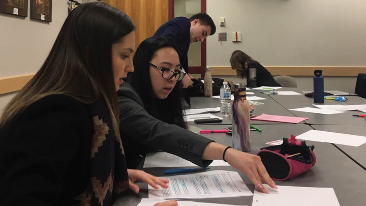 Team 58 works on the case around a boardroom in one of the BEC meeting rooms