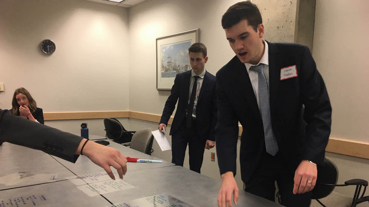 The team members review the overhead projector slides on the table