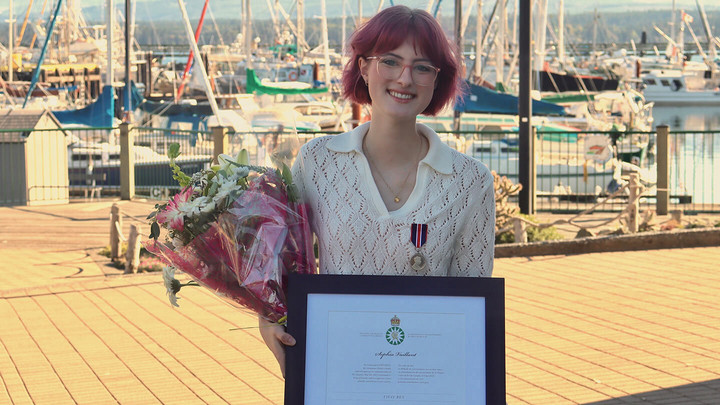 Sophia Vaillant down by the waterfront with her King Charles Coronation Medal and a certificate