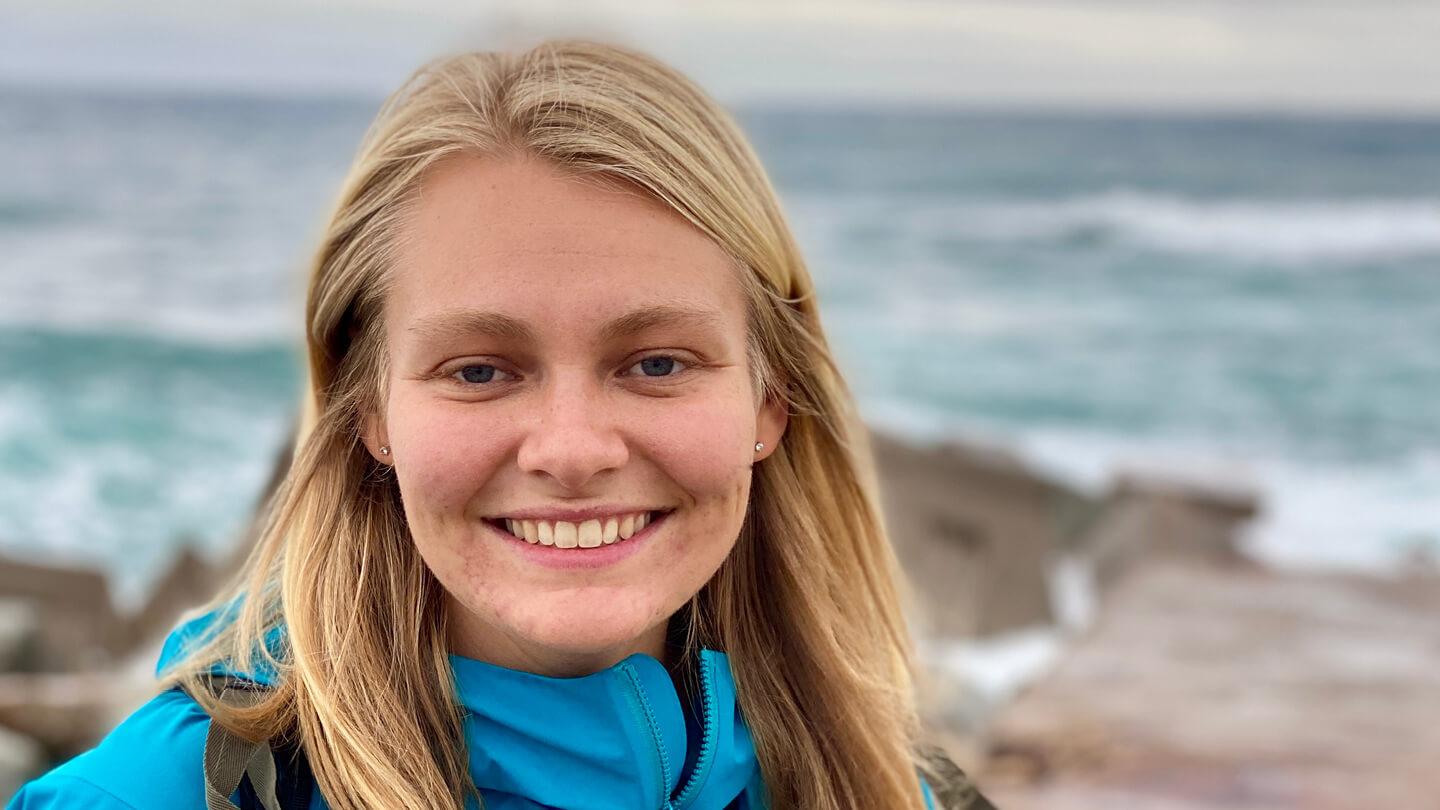 BCom grad Sydney Munk smiling by the ocean