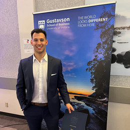 Blake Pilon poses in front of a Gustavson banner