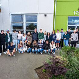 Students from COM 450 pose outside Level Ground Coffee