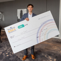 Taylor Duncan holds an oversized cheque for $30,000
