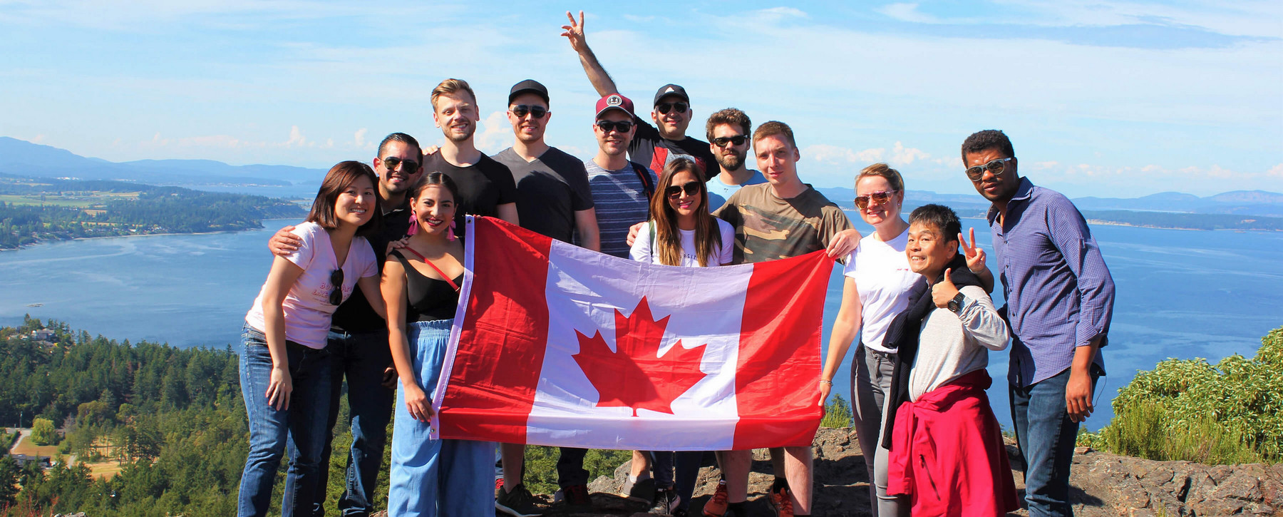 International students on a hike with a Canadian flag