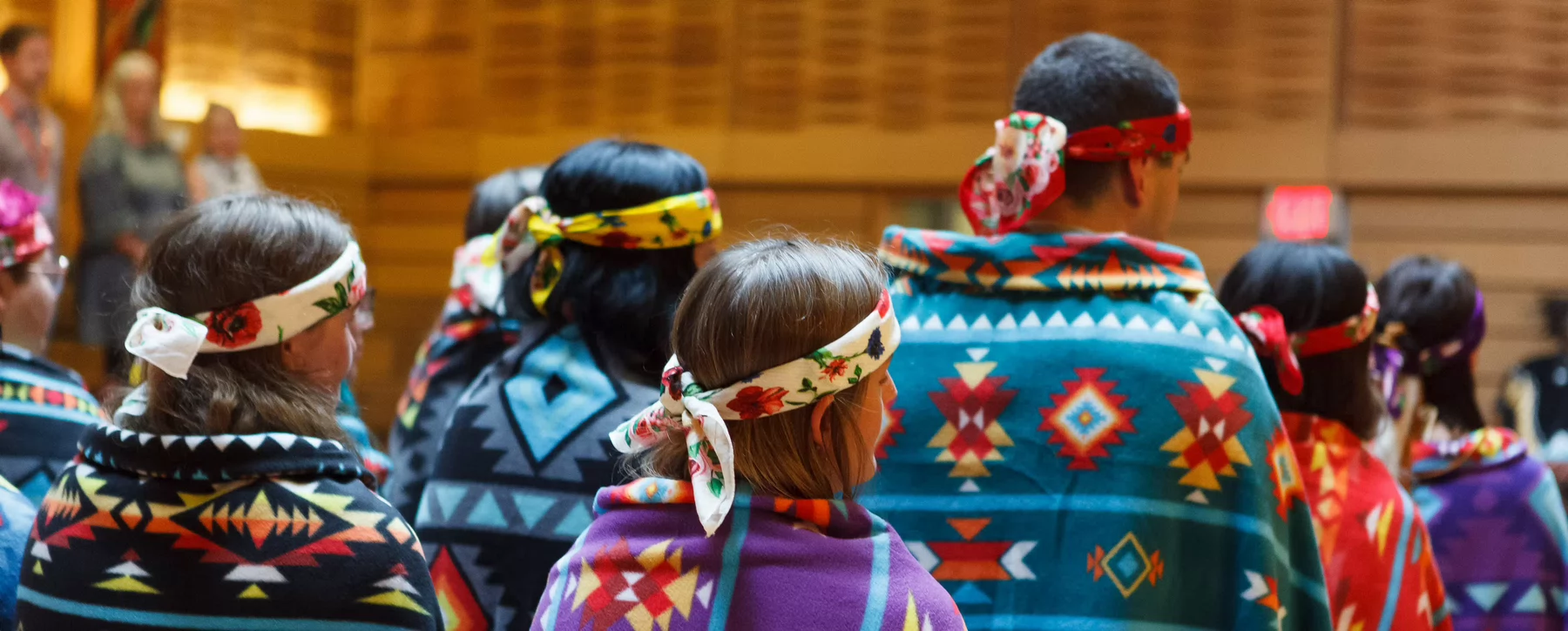 group of indigenous students wearing ceremonial blankets