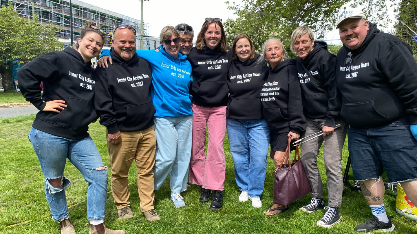 A group of people wear palliative care shirts.