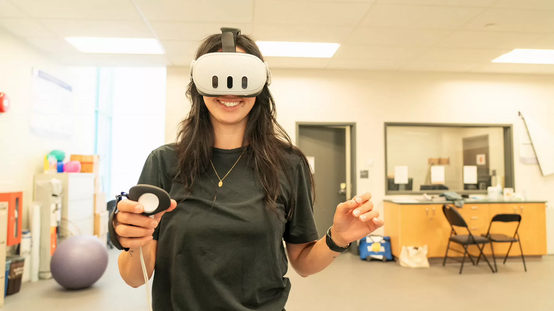 A person wearing virtual reality goggles over their eyes smiles at the camera.
