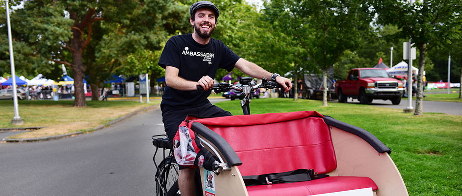 Carson Sage on a bicycle fitted with a cart