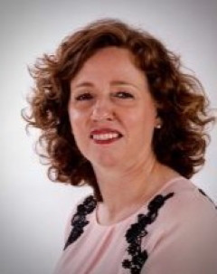 Dr. Christina West wearing a pink and black blouse