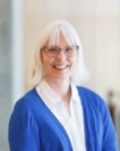 Sandy Polomark wearing a white shit and blue cardigan