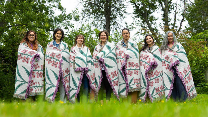 Fireweed Project research team members standing in a row wearing blankets