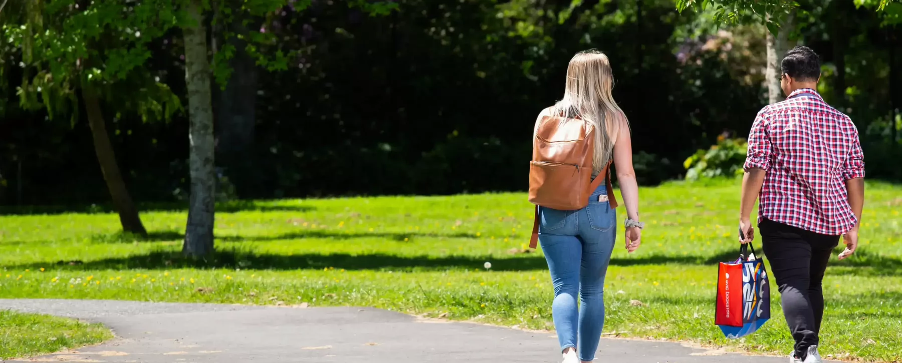 Two students walking across the street away from the camera