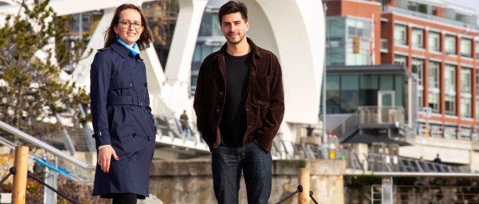 Katya Rhodes and Aaron Hoyle stand in front of a bridge in downtown Victoria