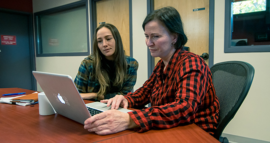 Student and professor working together at a computer