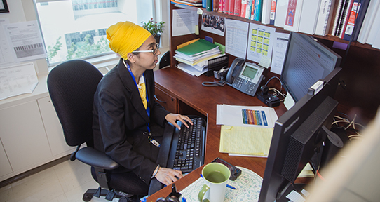 Health information science alumni sitting at a desk