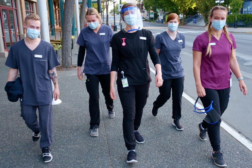 A group of UVic student nurses walk together outside a vaccine clinic in Victoria, where they have been working as part of their studies