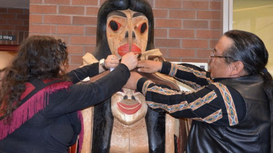 The transformation pole in the lobby of the HSD building is pictured. Two people are pictured carefully wrapping a blanket around the pole.