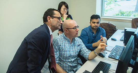 Students looking at a computer with an instructor