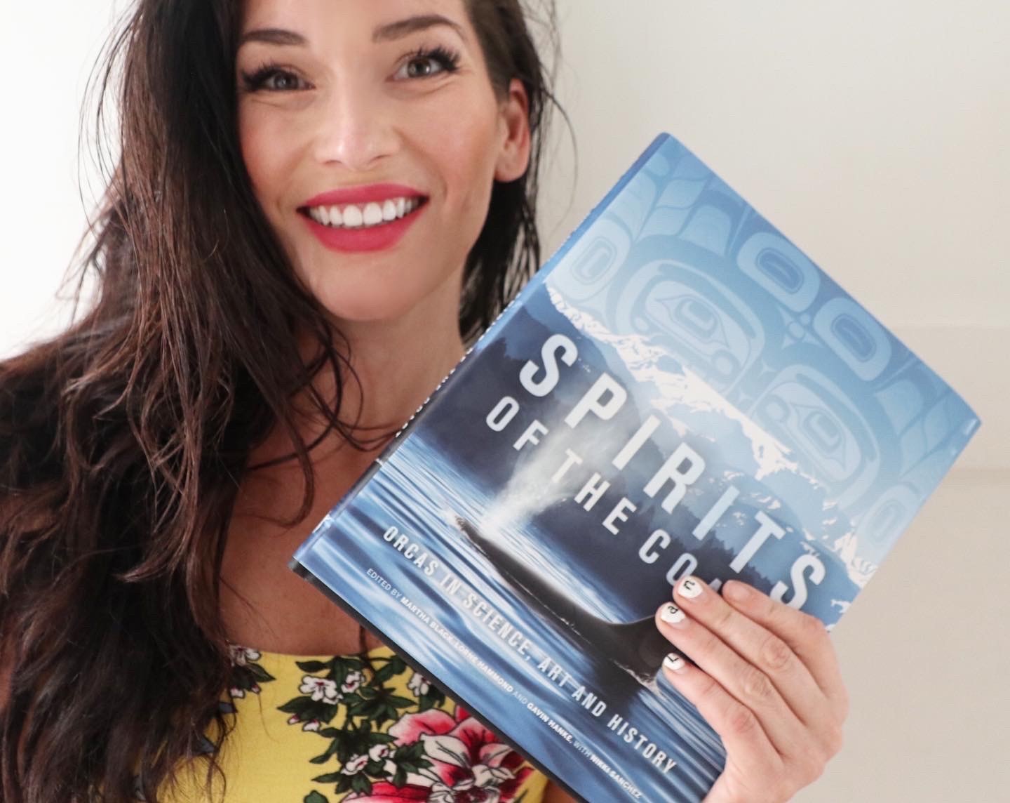 IGov PhD student Nikki Sanchez poses with a copy of Spirits of the Coast