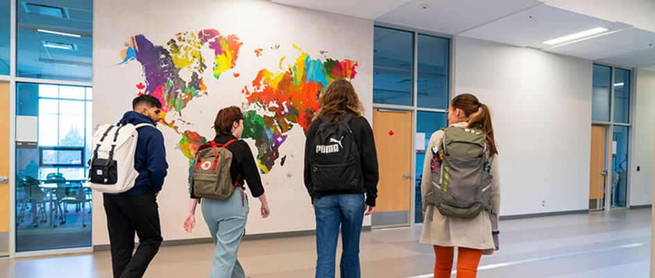 Four students walking inside a school building