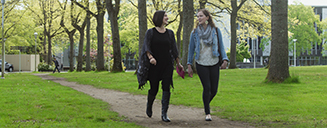 Two students walking across campus