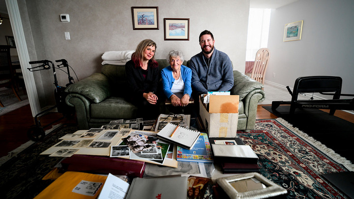 Miriam Libicki (centre), Rose Lipszyc (centre) and Mark Celinscak sit on the couch at Rose's Vancouver home. The coffee table is strewn with photographs.