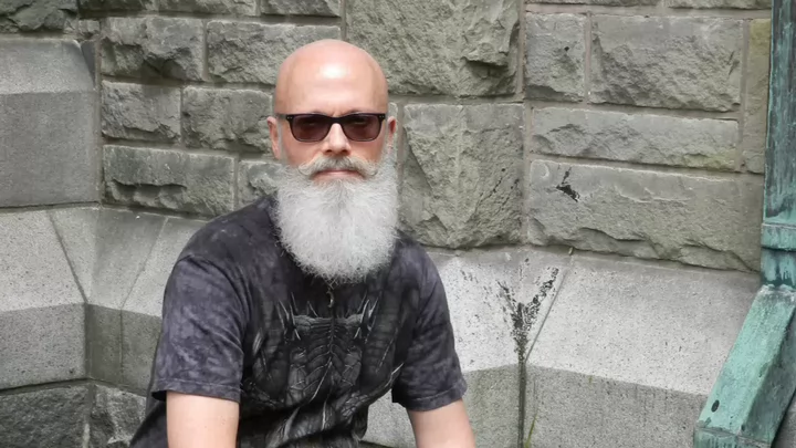 Michael Reed in front of a stone wall.
