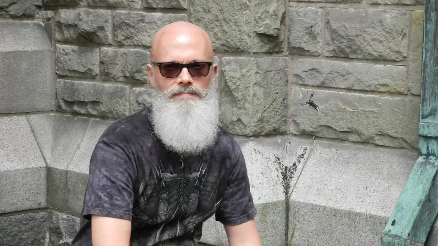 Michael Reed in front of a stone wall.
