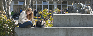 Student reading by the UVic fountain