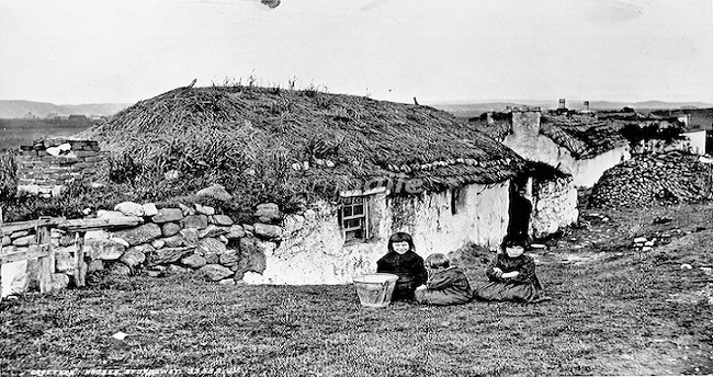 Photo of small homes with three children in the foreground.