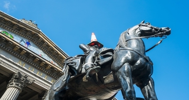 A statue of the Duke of Wellington with a cone on its head.