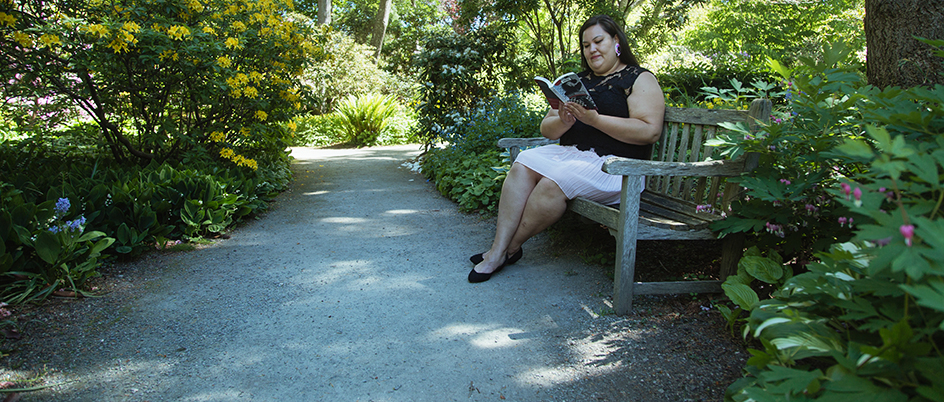 Student reading on a bench outside