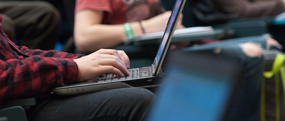 An instructor helps a student on a computer