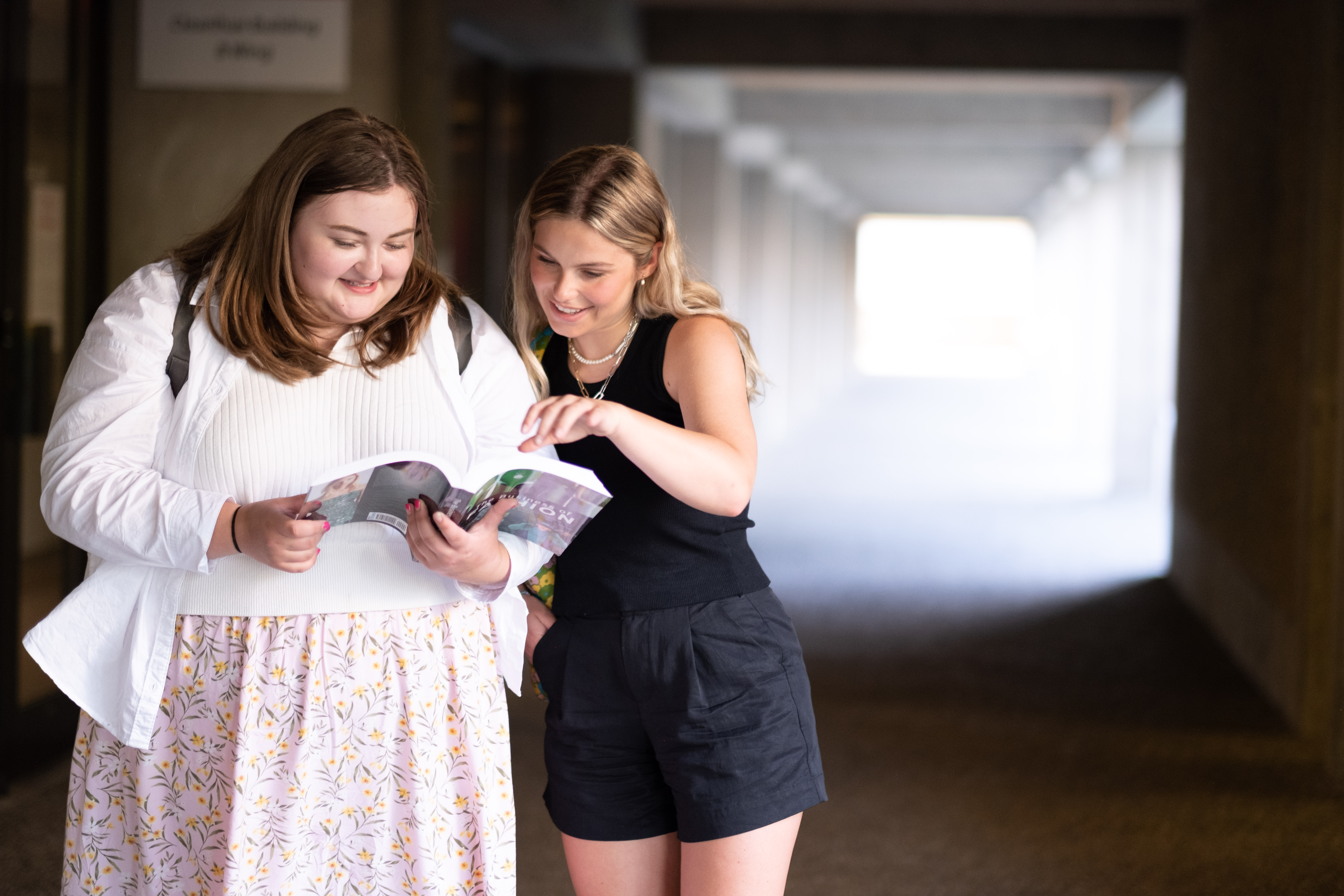 Students looking at a book together. 