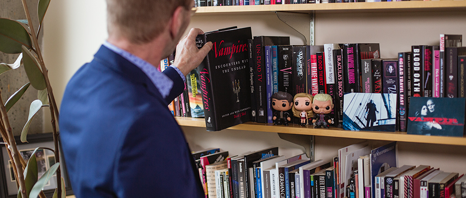 Professor Peter Golz pulling a book off a shelf