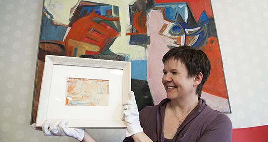 Caroline Riedel holding a framed work of art